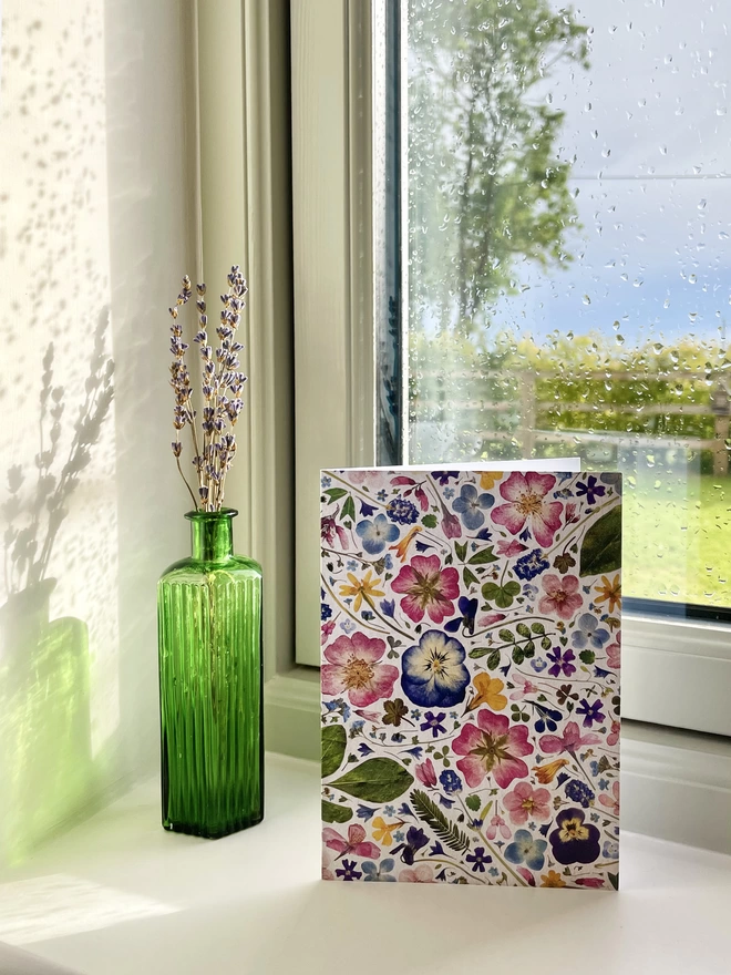 Greetings Card with Digitally Printed Pressed Flower Design Standing on Windowsill - Green Glass Bottle with Dried Lavender - Garden View with Tree, Hedge, Wooden Fence