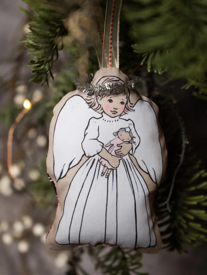 sweet christmas tree decoration a little blonded bobbed fair haird girl holding a doll hand sewn with a ribbon and small tinsel halo
