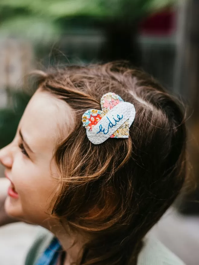Hetty and Dave Liberty Floral heart hairslide with name stitched in blue across a white scroll