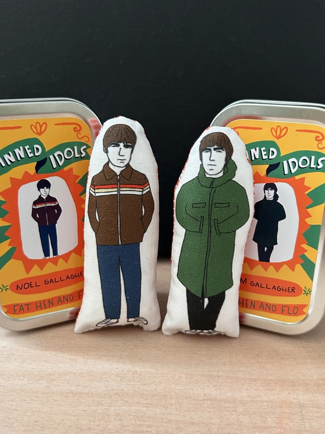 Mini illustrated fabric dolls of Oasis brothers Noel and Liam Gallagher.