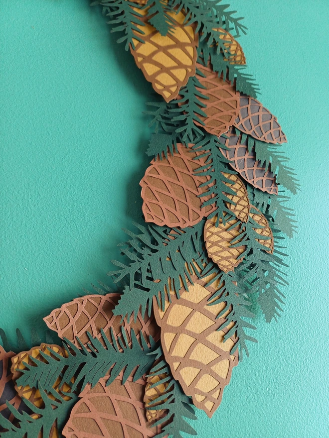 Mixed papercut pinecones and dark green papercut spruce on everlasting wreath