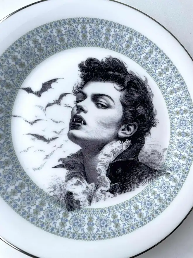 the vampire Louis wtih bats behind him, the image is victorian in black and white and is printed directly onto an ornate vintage plate
