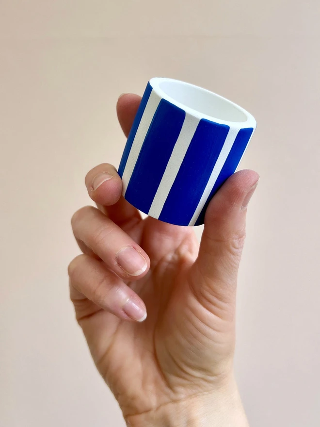 Image shows mini stripy pot held in hand to demonstrate proportions