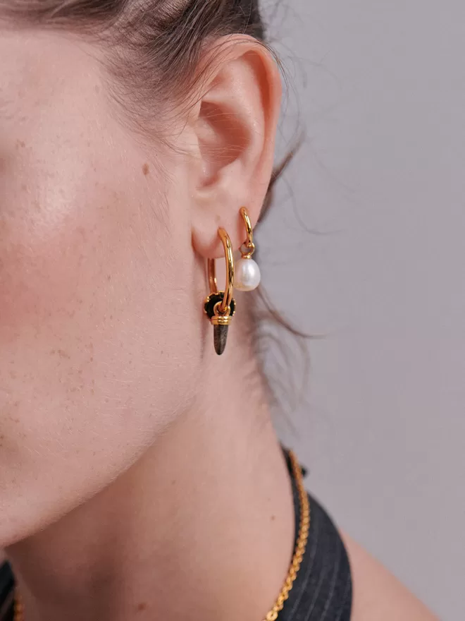 woman wearing gold hoops with charms
