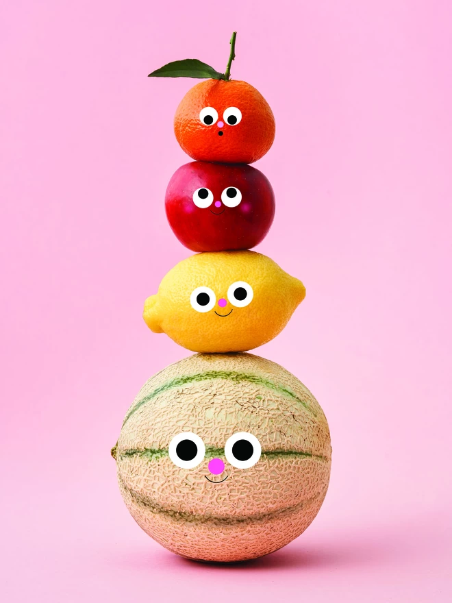 A totem of happy fruit on a pink background 