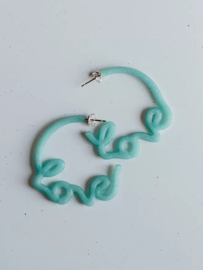 100% Recycled Ocean Plastic - 'Love' Hoop Earrings seen on a blank background.