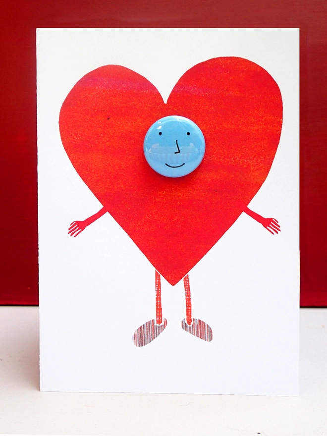 greeting card with big heart and happy face pin badge