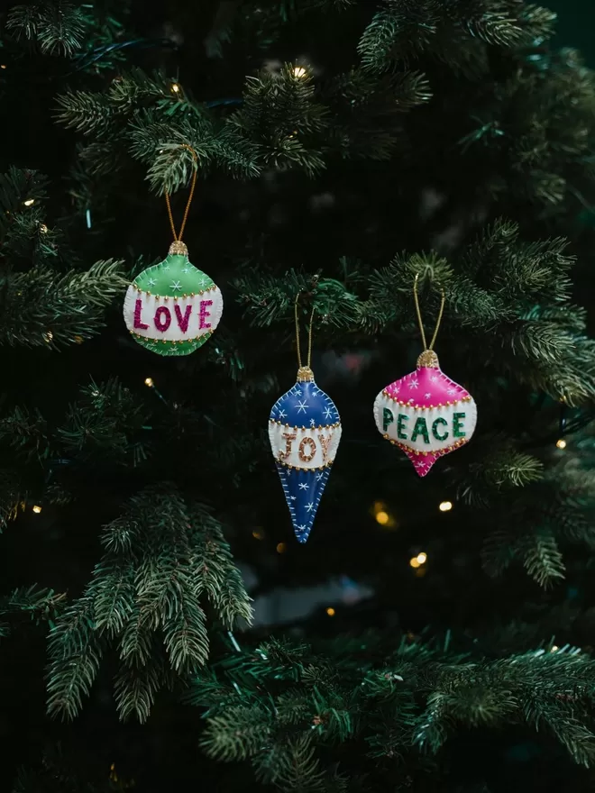Hetty and Dave christmas decorations, Love, Joy and Peace seen on a Christmas tree.