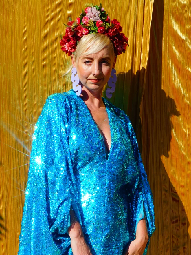 Turquoise Holographic Sequin V-neck Kaftan Gown seen on a woman wearing a flower headband.