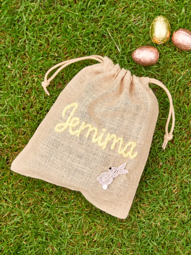 jute drawstring sack with brown knitted bunny decoration and yellow 'jemima' name 
