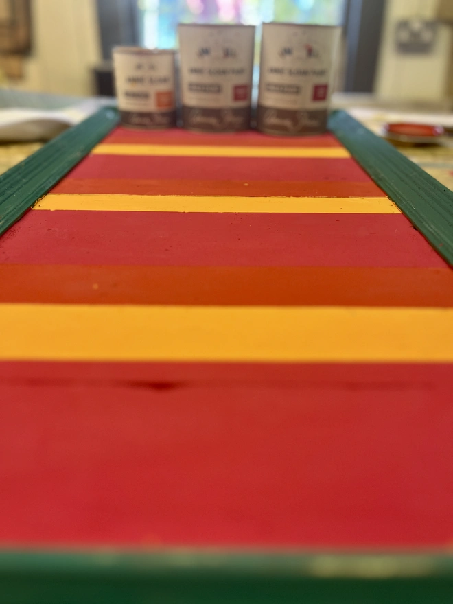 colourful Annie Sloan stripes painted on wooden sign ready to have the lettering painted on it.
