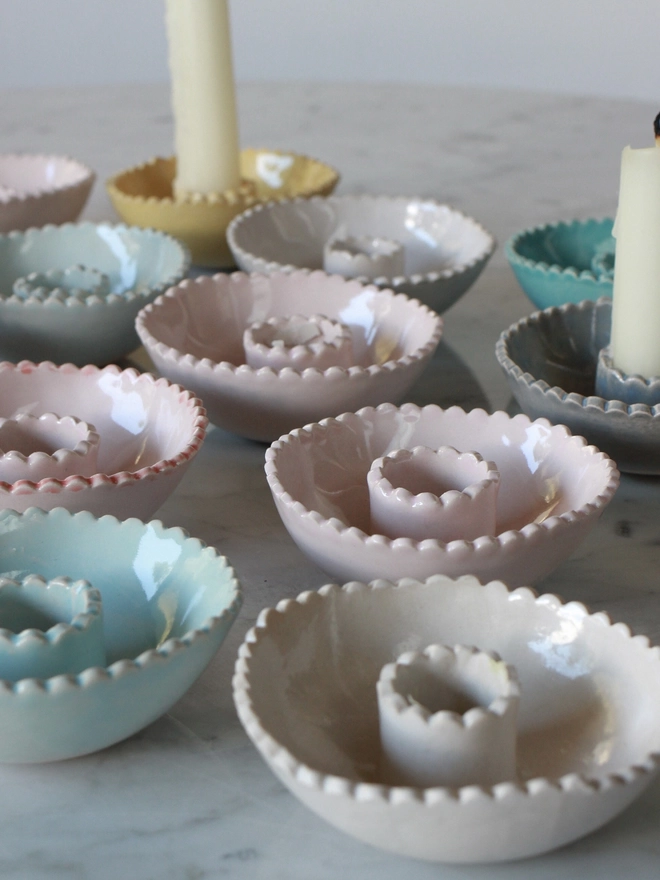 a group of pastel colour low candlestick holders
