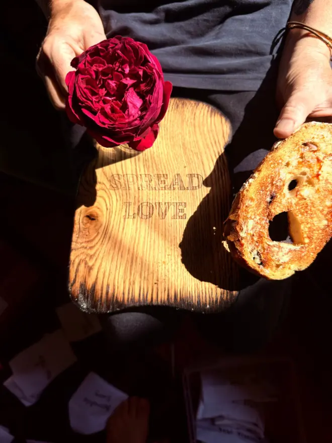 Spread love toast serving board with red rose and toast.