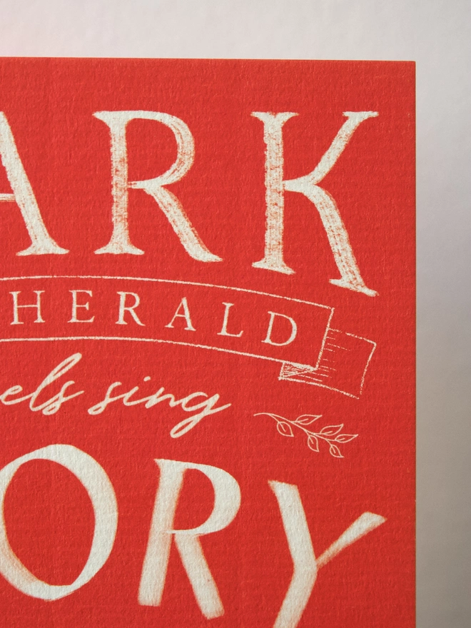 Red Christmas card with the words 'hark the herald angels sing' on the front