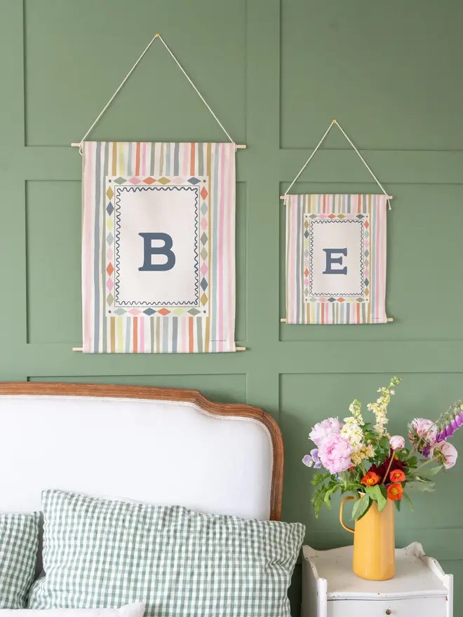 Stripe Initial Fabric Banner, hanging on a green wall. 