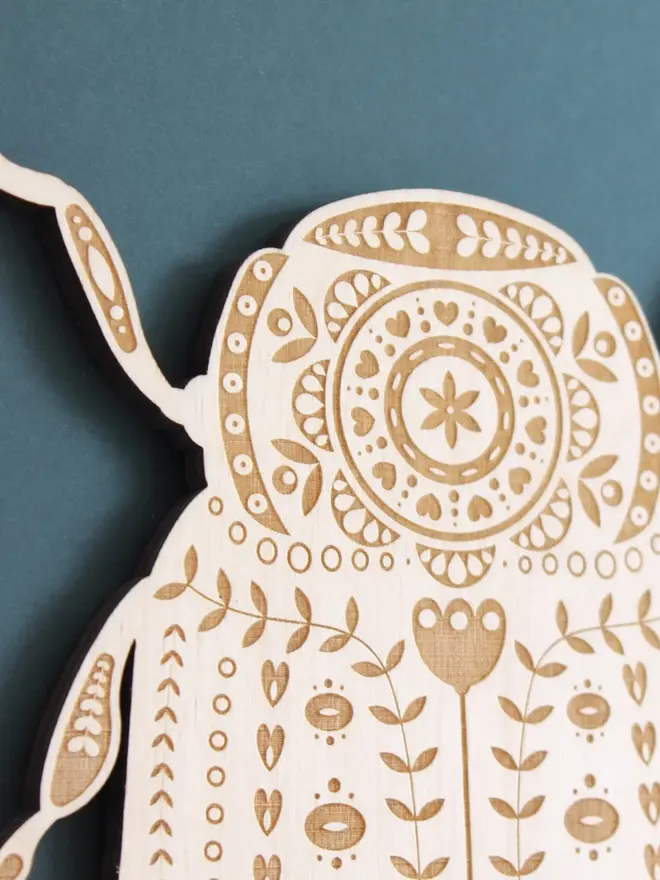 Folk Art Beetle Wall Hanging, wooden insect decoration hanging on a wall. 