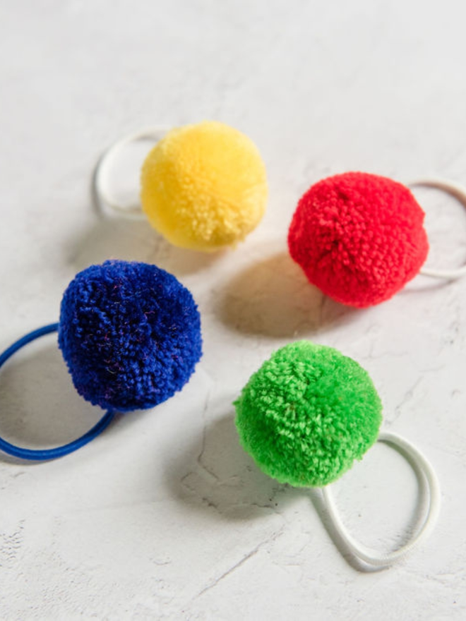 pom pom hair ties (set of four). four pom pom hair ties in primary colours.