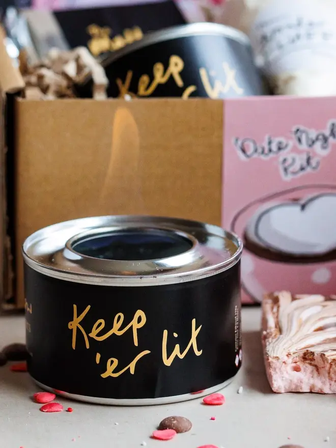 Date Night S'mores And Hot Chocolate Kit, the burner pictured in front of the rest of the kit on a marble surface. 