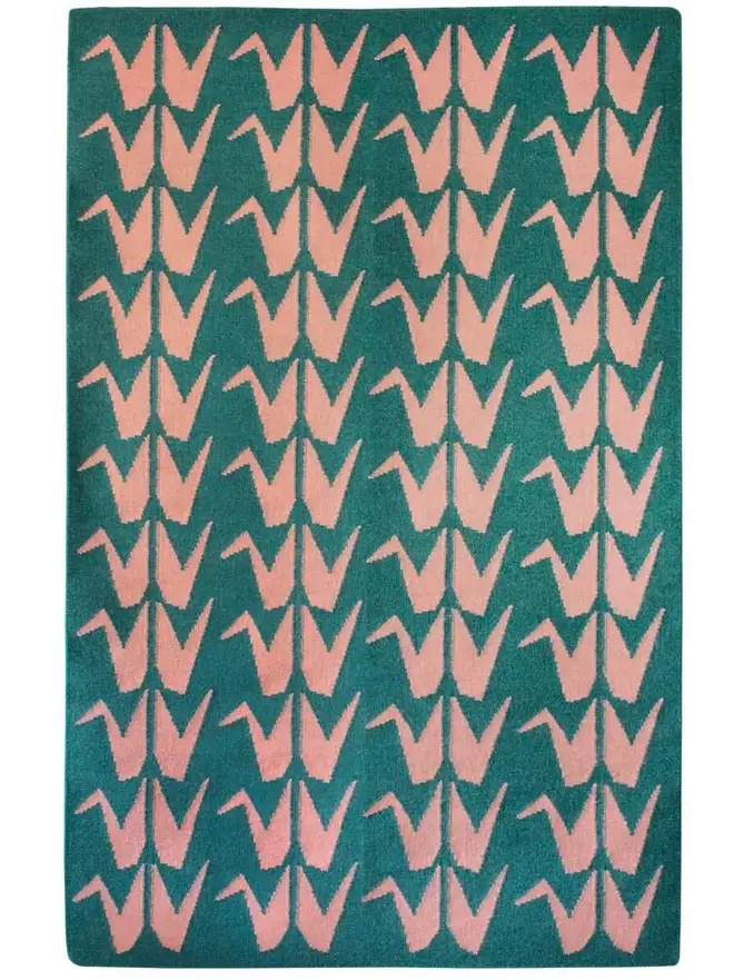 Crane Flatweave Rug, a colourful rug sitting on a plain surface. 