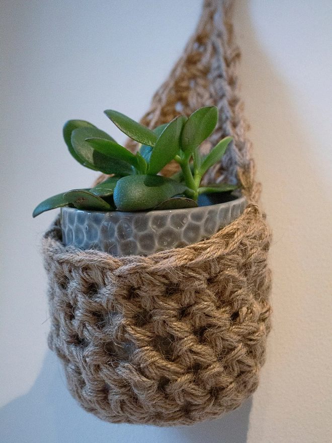 indoor small brown jute hanging wall planter, fabric wall mounted plant holder, handmade crochet plant basket, handmade sustainable crochet decor, rustic natural organic homeware accessories, hanging plant holder 