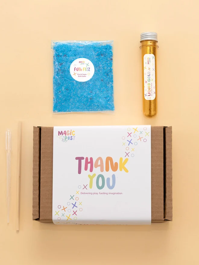 sensory party potion box. tube of gold glitter and blue bath salts photographed with packaging box.