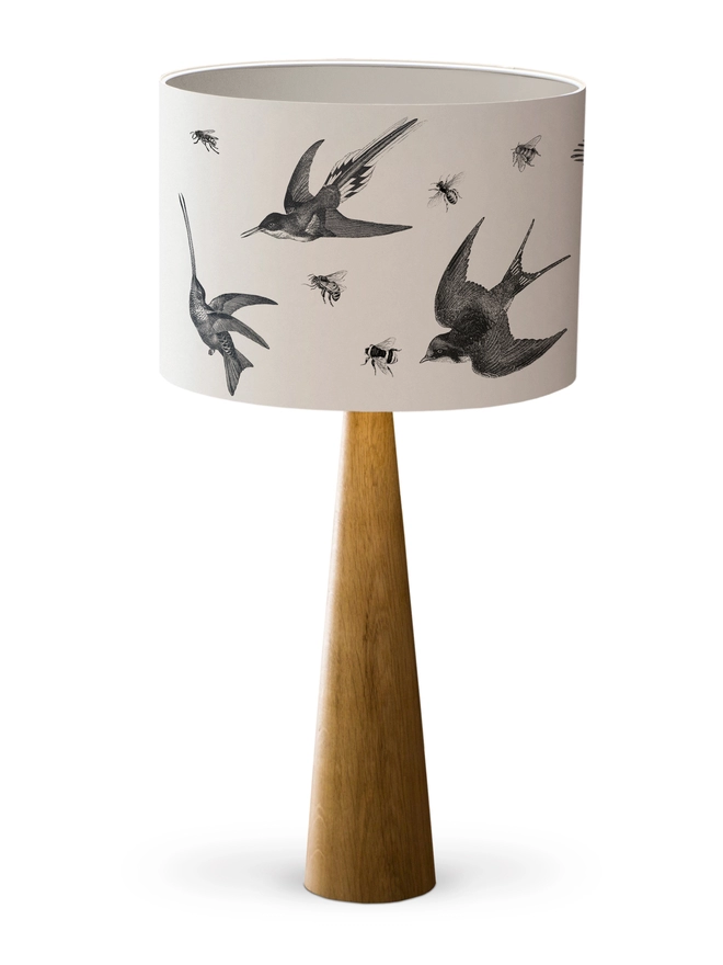 Drum Lampshade featuring birds and bees with a gold heart with a white inner on a wooden base on a white background