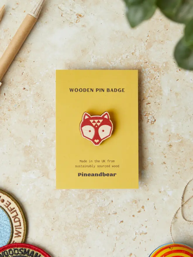 Fox wooden pin badges of a yellow presentation card