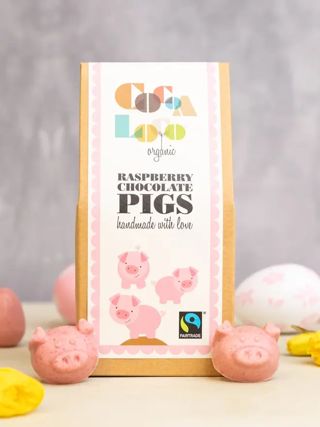 White Chocolate & Raspberry Pigs with their box on a table with easter eggs