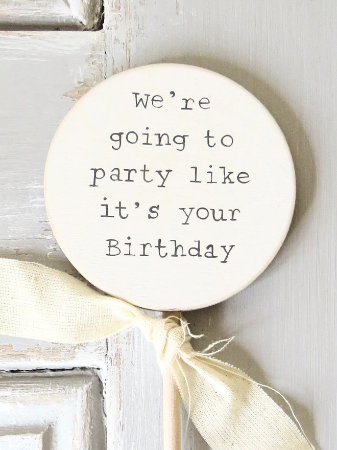 wooden circle shaped cake topper with hand painted message and custom ribbon