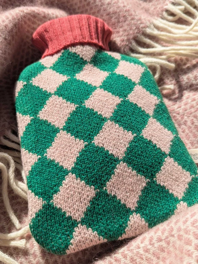 COLOURFUL HOT WATER BOTTLE COVER DISPLAYED ON A ON A BLANKET