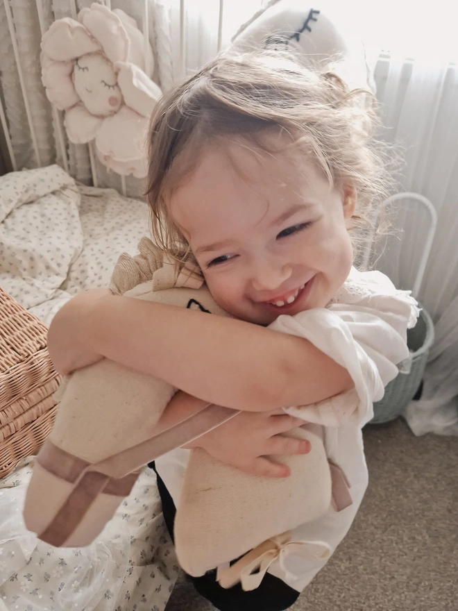 Horse Baby Rattle Toy, a child with a horse baby rattle toy in a bedroom surrounded by other bedroom accessories. 