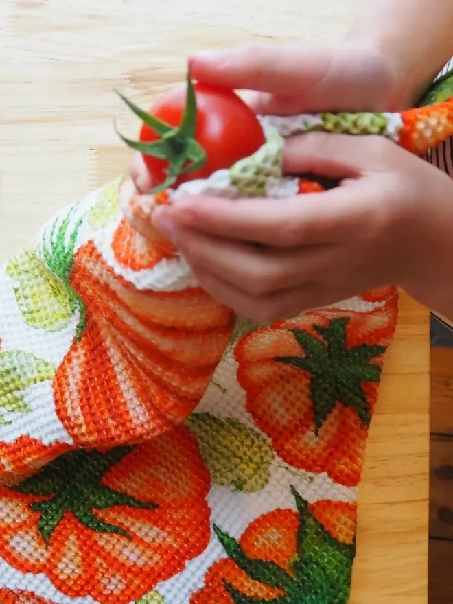 Tomato Waffle Tea towel, cleaning a tomato. 
