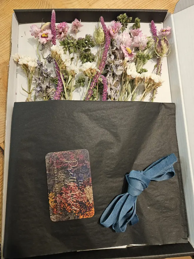 Letterbox Flowers, a colourful collection of flowers sitting in their letterbox packaging on a wooden surface. 