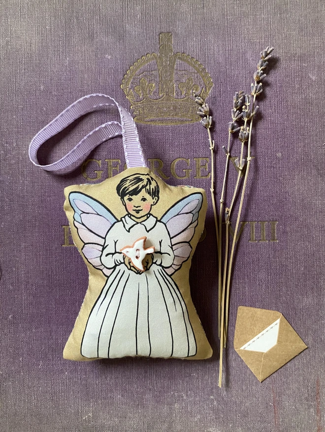 a tooth fairy boy holding a white peace dove button with a lilac ribbon for hanging