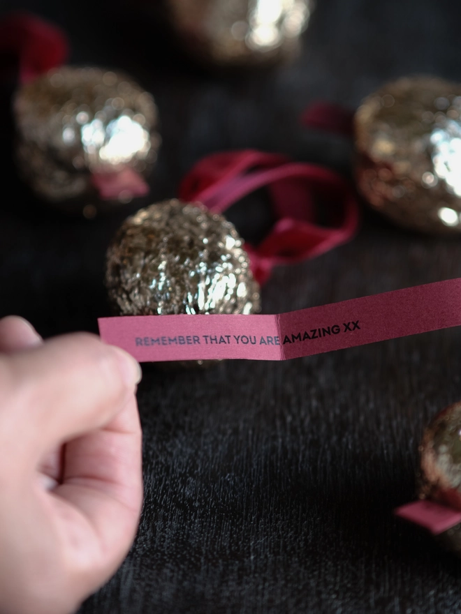 Handmade walnut Christmas ornament with delicate gold gilding, showing the natural shape and grain of the wood. A traditional, nostalgic Christmas tree decoration with timeless old-fashioned charm.