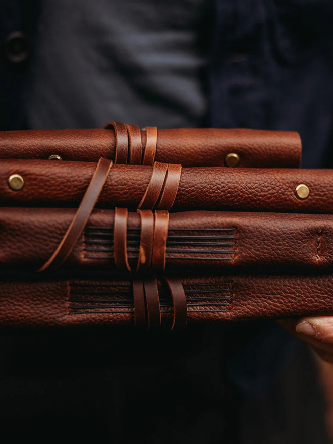  leather refillable ring binder. a stack of dark brown ring binders.