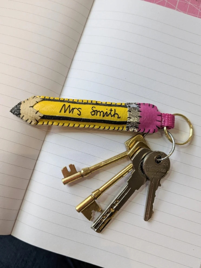 Personalised leather nostalgic pencil keyring. A pencil shaped keyring with a teachers name embroidered on the front