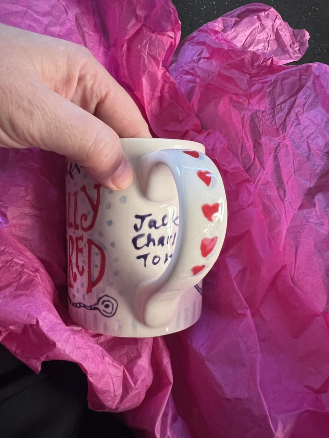 Hand-painted Retirement Mug with hearts down the handle and the names of who it was from underneath the handle
