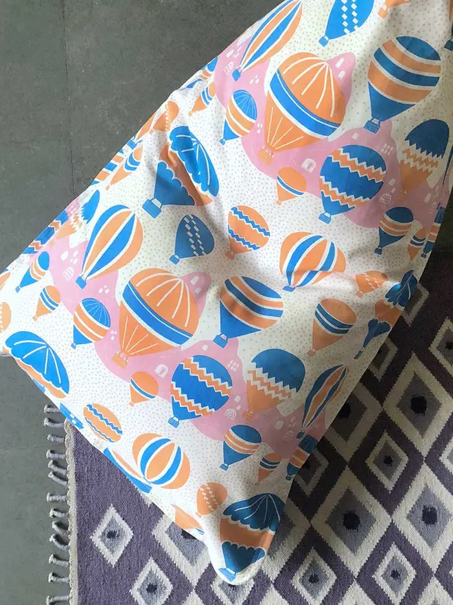 Balloons At Dawn Bean Bag Cover, a colourful bean bag on a decorated floor. 