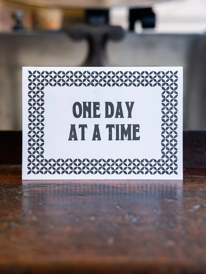 Letterpress card with text design "One day at a time"