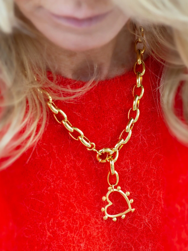 Make it your signature. The Romeo Necklace pairs a bold gold-plated chain with a sculptural studded heart charm for a striking yet wearable finish. This front fastening statement necklace is perfect worn solo or layered, bringing contemporary heart jewellery energy to every outfit.