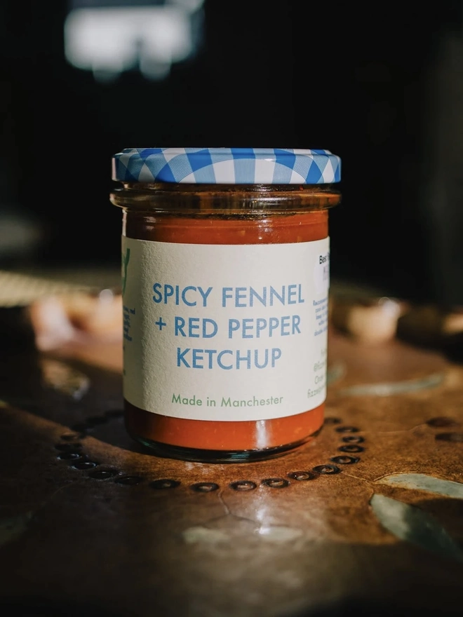 Spicy Fennel & Red Pepper Ketchup Jar, seasoning jar on a table. 