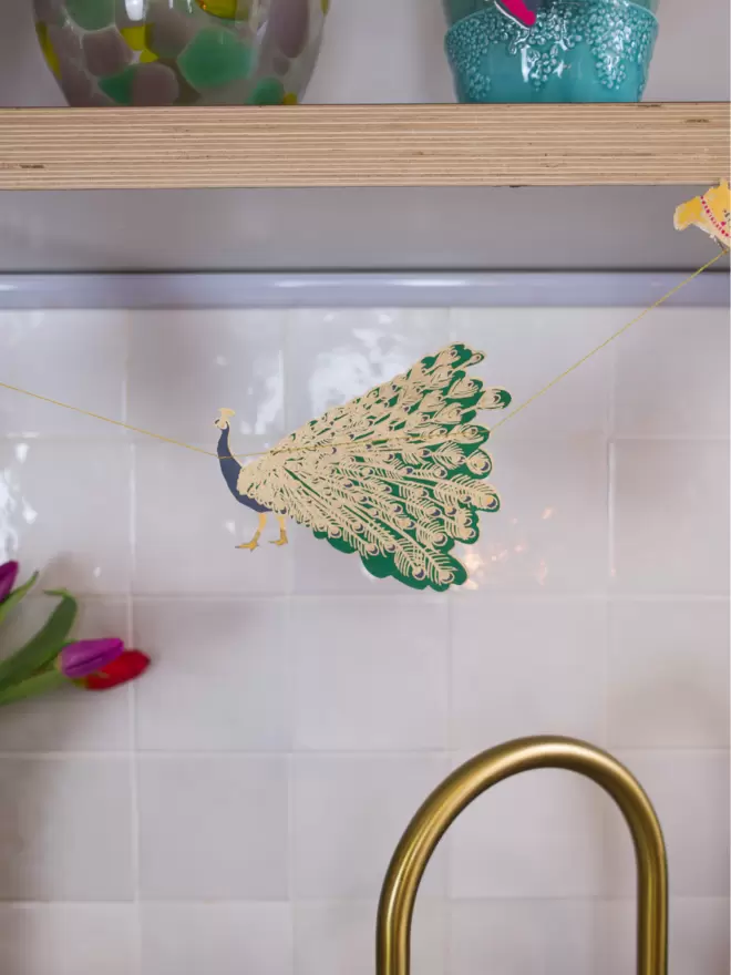 Gold tap with brightly embellished peacock shape