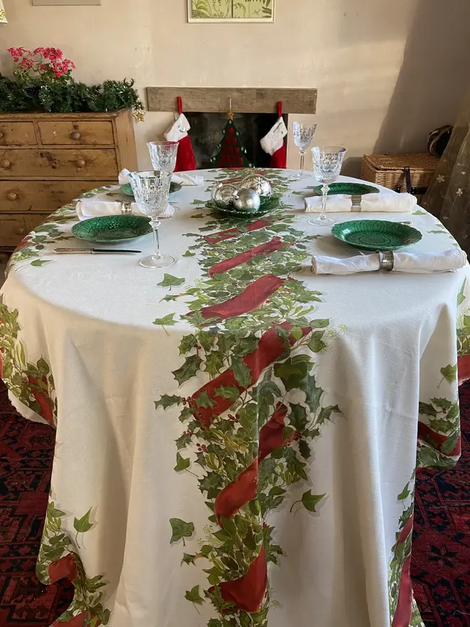 christmas garland centrepiece tablecloth. a white tablecloth emblazoned with a christmas garland on a table.