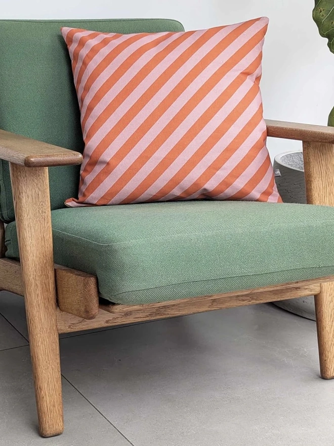 Cotton Print Patterned Cushion, a cushion sitting on a green chair in a kitchen. 