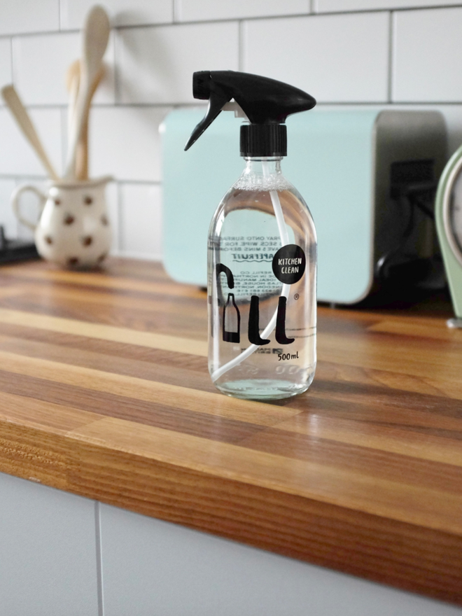 Kitchen Clean. A spray labelled Fill Kitchen Clean on a wooden counter.