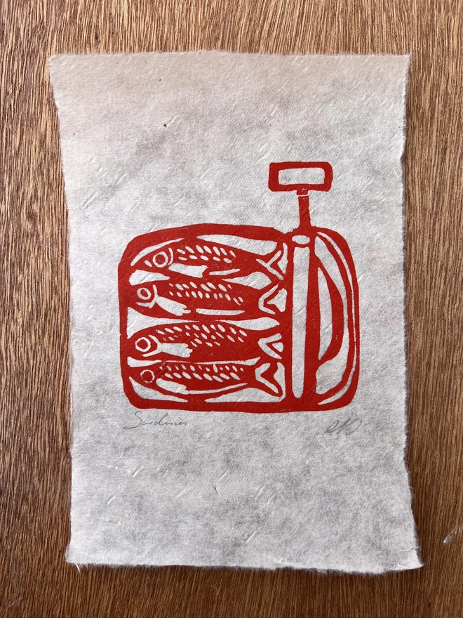 Hand printed sardine lino print featuring detailed sardines arranged in a bold folk-inspired design, printed on natural paper.  