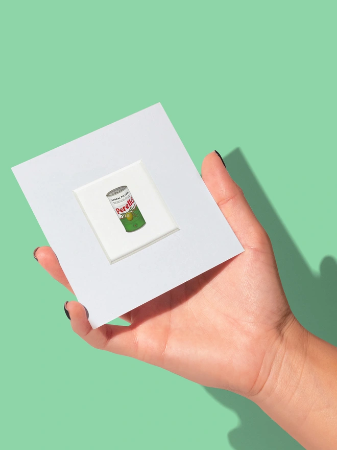 Food-inspired mini art print in a white paper mount, featuring an illustration of a Perello Olives tin. A stylish design perfect for food lovers and collectors of vintage food packaging art.