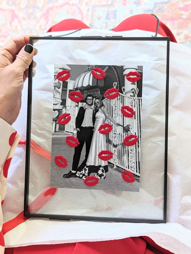 Framed couples photo, with embroidered lips held on knee