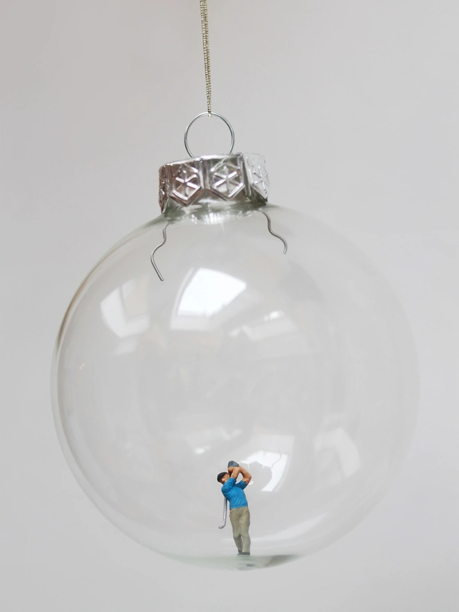 Miniature figure of a golfer in a glass Christmas bauble 